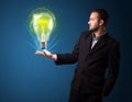 Businessman holding glowing lightbulb in his hand