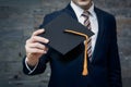 Businessman is holding graduation hat business education concept, signifying academic achievement Royalty Free Stock Photo