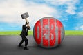 Businessman holding hammer hitting cracked DEBT ball with sky cl