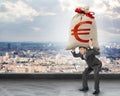 Businessman holding heavy moneybag with euro sign