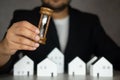 Businessman holding hourglass and many of wood home background