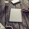 Businessman holding ink pen about to write on a blank white piece of paper