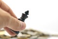 Businessman holding a King Chess is placed on a pile of coins.using as background business concept and Strategy concept Royalty Free Stock Photo