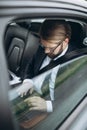 Businessman holding laptop on knees while driving car Royalty Free Stock Photo