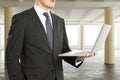 Businessman holding laptop in sunny spacious hangar area with co Royalty Free Stock Photo