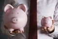 Businessman Holding Large And Small Piggy Bank Royalty Free Stock Photo