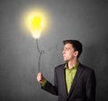 Businessman holding a lightbulb balloon