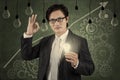 Businessman holding lightbulb with upward graph 2