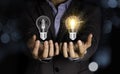 Businessman holding lightbulbs which one lamp glowing and one lamp black out.Creativity idea concept.