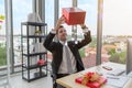 Businessman holding and looking red gift box with falling magic stars in office - Christmas and Happy ne Royalty Free Stock Photo