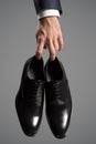 Businessman holding luxury leather shoes in hand. Royalty Free Stock Photo