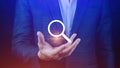 Businessman holding magnifying glass icon hologram in hand. Technology business and job search concept Royalty Free Stock Photo