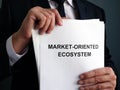 Businessman holds market-oriented ecosystem MOE plan Royalty Free Stock Photo