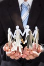 Businessman holding metal team in cupped hands