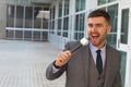 Businessman holding a microphone in office space Royalty Free Stock Photo