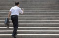 Businessman holding mobile and in hurry to run up on stairs Royalty Free Stock Photo