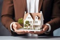 Businessman holding model house Close up. Loan, investment or Home insurance concept Royalty Free Stock Photo
