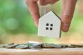 Businessman holding a model house model is placed on a pile of coins.using as background business concept and real estate concept Royalty Free Stock Photo