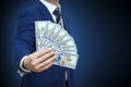 Businessman holding Money Cash Dollars in hands of passing them to the client. Businessman giving money, united states dollar Royalty Free Stock Photo