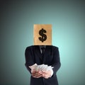 Businessman holding money with a paper bag on head