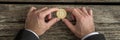 Businessman holding one golden Bitcoin in a wide cropped image Royalty Free Stock Photo