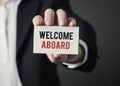 Businessman holding paper with text Welcome Aboard. Businessman holding card. Royalty Free Stock Photo