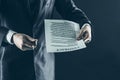 Closeup of a businessman holding a pen and a document with the terms of the contract. Royalty Free Stock Photo