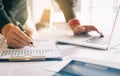 Businessman holding pen and pointing paper chart summary analyzing annual business report with using laptop at room office desk. Royalty Free Stock Photo