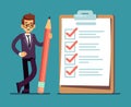 Businessman holding pencil at big complete checklist with tick marks. Business organization and achievements of goals