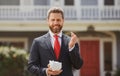 Businessman holding piggy bank on home house background. Handsome caucasian man holding piggybank for money for savings. Royalty Free Stock Photo