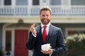 Businessman holding piggy bank on home house background. Handsome caucasian man holding piggybank for money for savings. Royalty Free Stock Photo