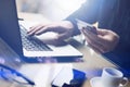 Businessman holding plastic credit card in hand and using laptop computer while sitting at the wooden table.Man making Royalty Free Stock Photo