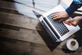 Businessman holding plastic credit card in hand and using laptop computer while sitting at the wooden table.Reflections Royalty Free Stock Photo