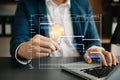 Businessman holding and putting lightbulb on coins stack on table for saving energy and money concept.Idea saving energy and Royalty Free Stock Photo