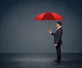 Businessman holding red umbrella.