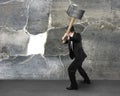 Businessman holding sedgehammer to crack wall Royalty Free Stock Photo