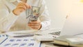 Businessman holding several $100 bills in his hand, payroll concept.