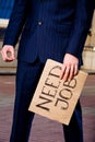Businessman holding sign Need Job outdoors