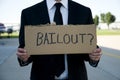 Businessman holding a sign that says bailout? Royalty Free Stock Photo