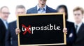 Businessman holding a sign with the word Possible