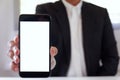 Businessman holding smartphone forward empty white screen for your text or picture.