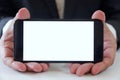 Businessman holding smartphone forward empty white screen for your text or picture. Royalty Free Stock Photo