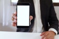 Businessman holding smartphone forward empty white screen for your text or picture Royalty Free Stock Photo