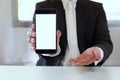 Businessman holding smartphone forward empty white screen for your text or picture