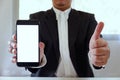 Businessman holding smartphone forward empty white screen for your text or picture