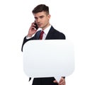 Businessman holding a speech bubble while talking on the phone Royalty Free Stock Photo