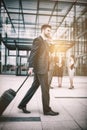 Businessman holding suitcase talking on mobile phone Royalty Free Stock Photo