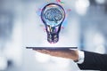 Businessman holding tablet with creative light bulb sketch on blurry bokeh background. Idea and inspiration concept Royalty Free Stock Photo