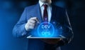 Businessman holding tablet with Dev Ops Development Operations icons on screen Royalty Free Stock Photo