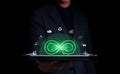 Businessman holding tablet with infinity symbol with circle economic environment icon floating and green light. Future sustainable